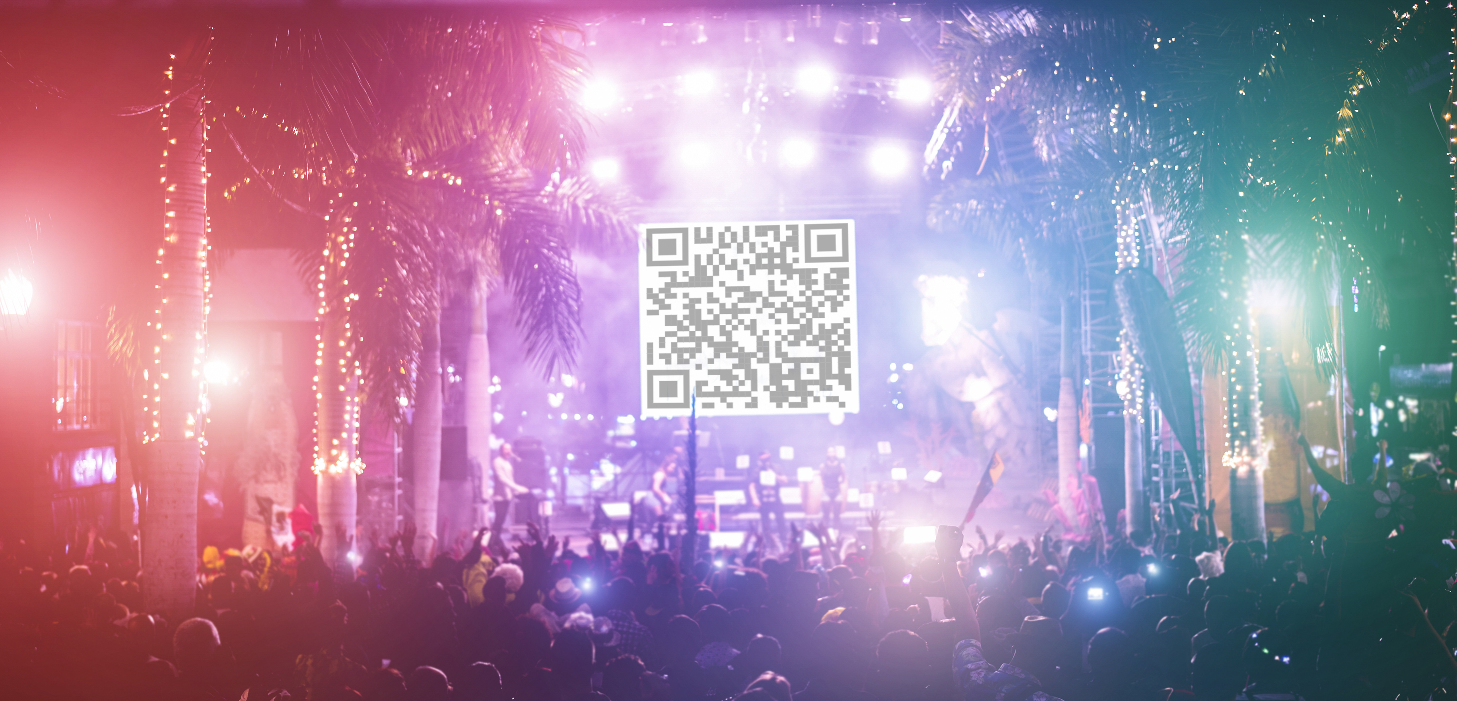 Outdoor concert crowd with a QR code displayed on stage for fans to scan and win